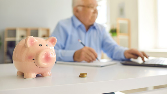 Mann mit Sparschwein Sparschwein mit Mann im Hintergrund